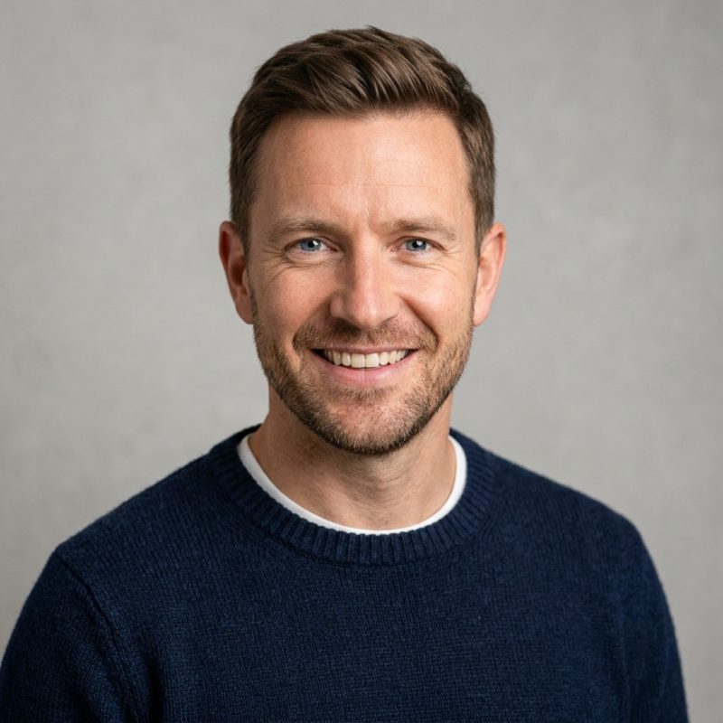 Man smiling in navy sweater