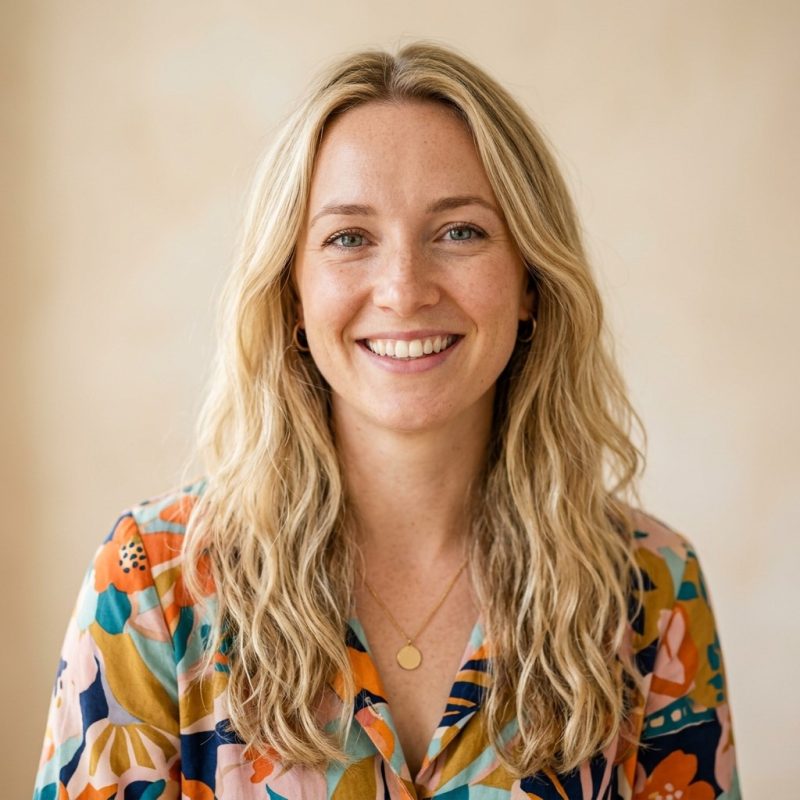 Blonde woman in floral shirt smiles.